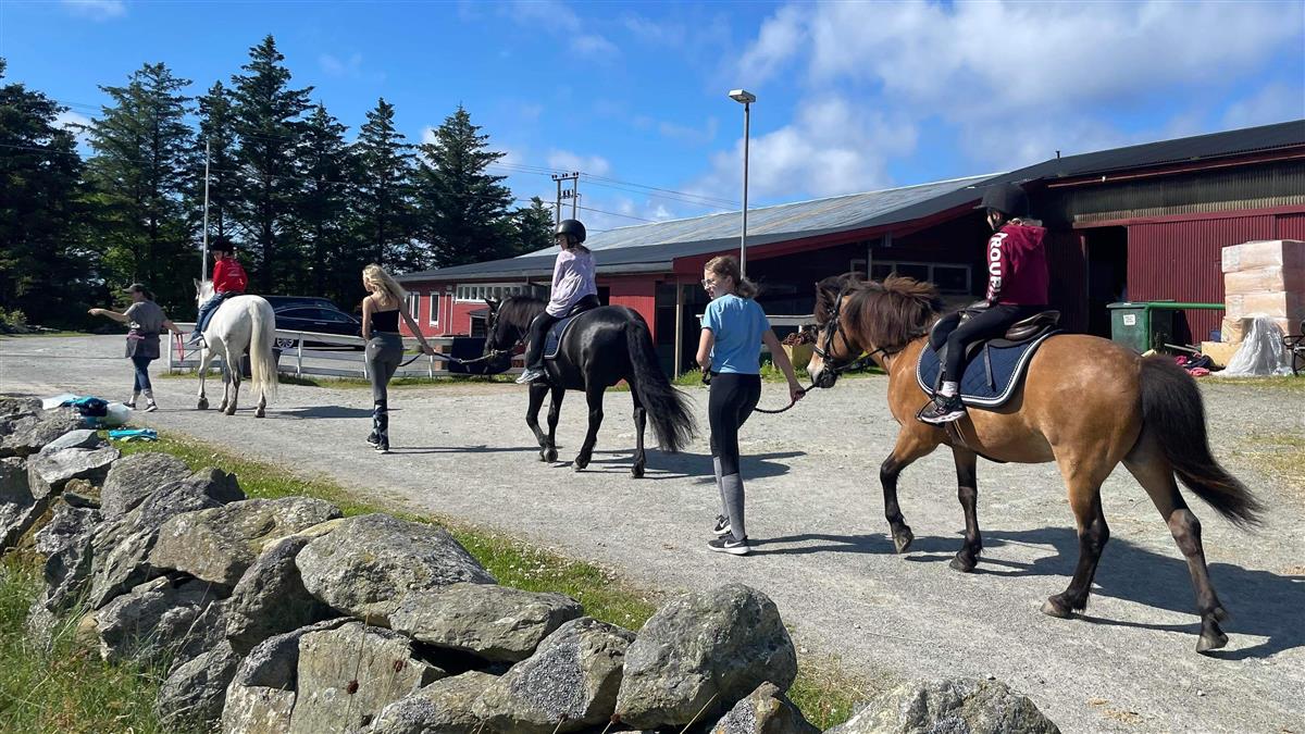 Sommergøy med barn som rir hester - Klikk for stort bilde
